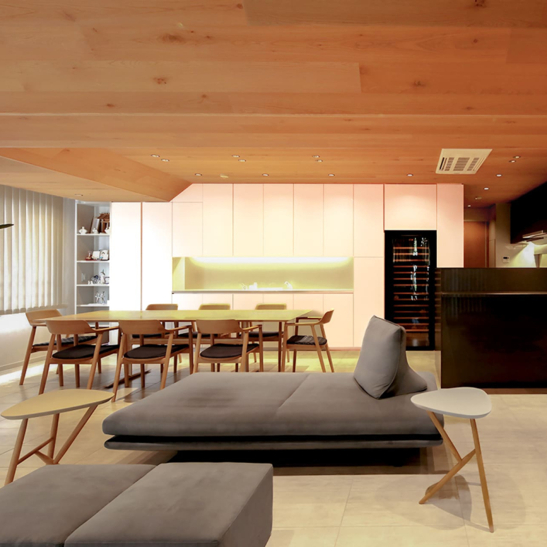 Projet de rénovation d’une maison japonaise à Tokyo. Une cave à vin intégrée dans un meuble sur-mesure dans la cuisine ouverte sur le salon.
