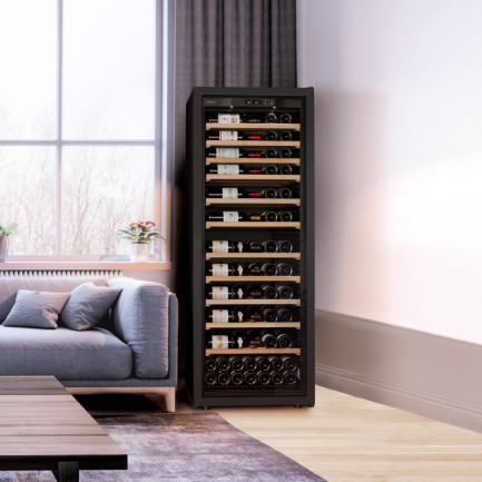 Cave à vin grande taille porte vitrée avec cadre noir en pose libre dans un salon à côté du canapé - La Première EuroCave Cave à vin grande taille porte vitrée avec cadre noir en pose libre dans un salon à côté du canapé - La Première EuroCave