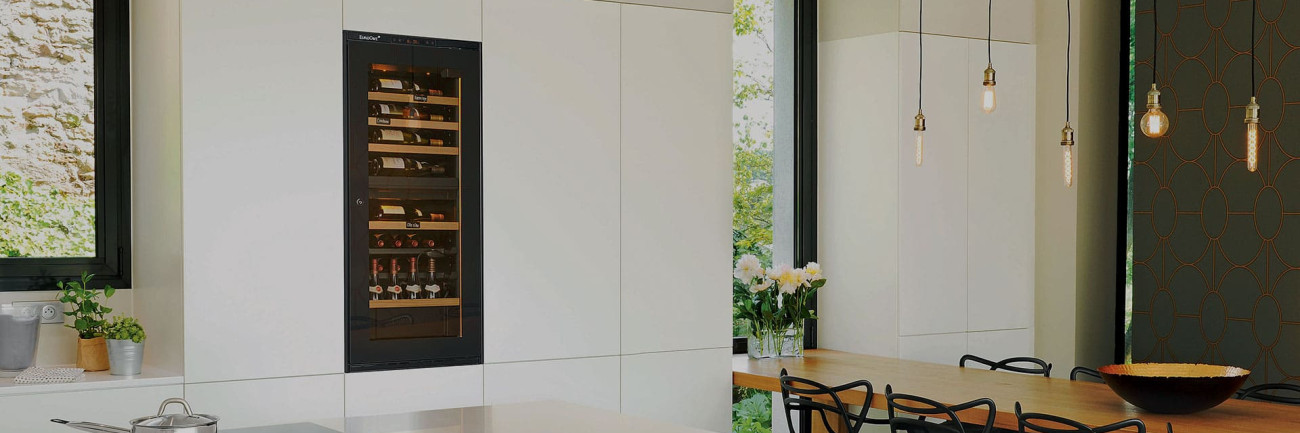 Cave à vin de service encastrée dans un meuble d'une cuisine blanche haut de gamme. Cave à vin de service encastrée dans un meuble d'une cuisine blanche haut de gamme.