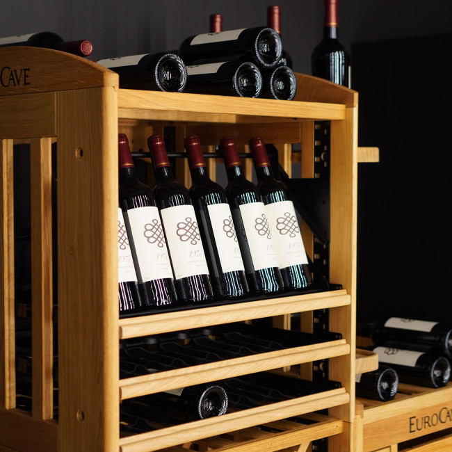 Présentoir articulé sur clayette coulissante pour mettre en valeur les bouteilles de vin et faciliter la visibilité et la lecture des étiquettes. Présentoir articulé sur clayette coulissante pour mettre en valeur les bouteilles de vin et faciliter la visibilité et la lecture des étiquettes.