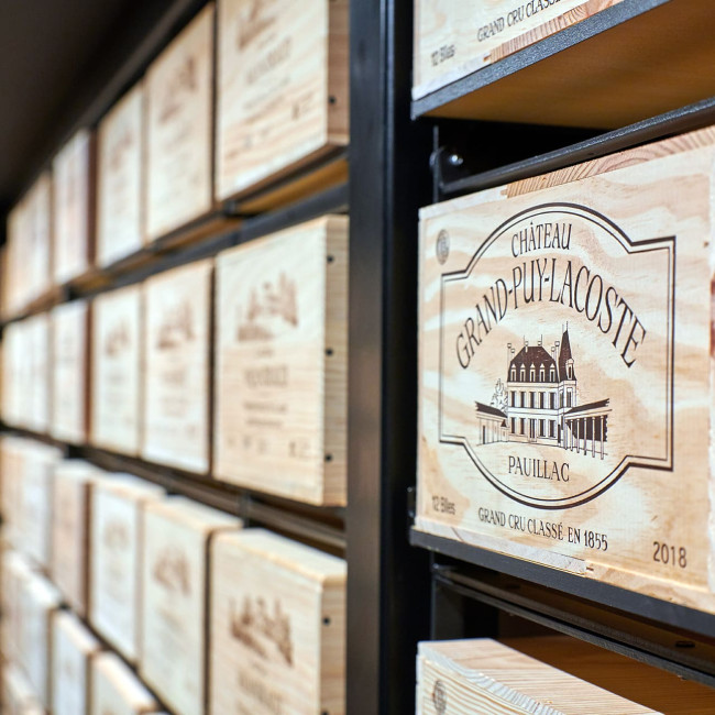 Étagère composée de plusieurs Modulorack assemblés, formant un mur de vin avec des caisses en bois sur une structure en métal noir, au design industriel et authentique.